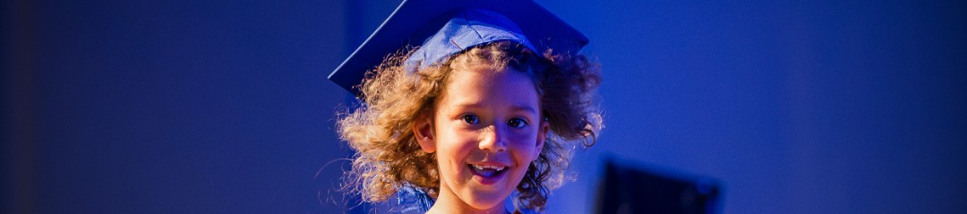 Smiling ODCS kindergarten graduate in a cap and gown